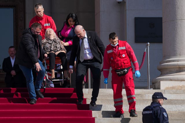 Medics carry a lawmaker injured after chaos erupted during a parliamentary session in Belgrade, Serbia 