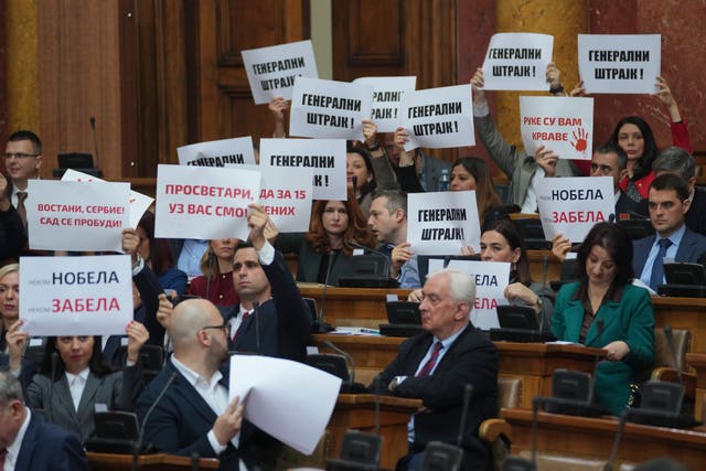 Opposition lawmakers hold banners reading 'general strike' during a parliamentary session in Belgrade, Serbia