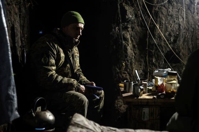 A Ukrainian serviceman sits in a shelter