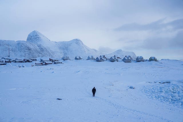 A woman walks on a beach in Nuuk, Greenland