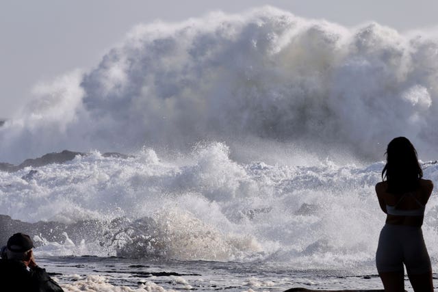 People watch as huge swells hit the beaches on the Gold Coast