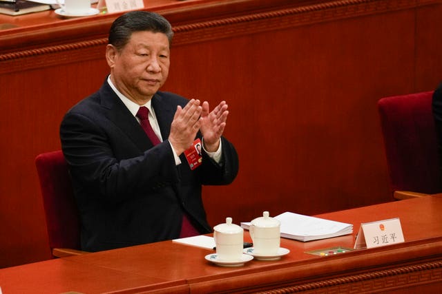 Chinese President Xi Jinping applauds during the opening session of the National People’s Congress at the Great Hall of the People in Beijing