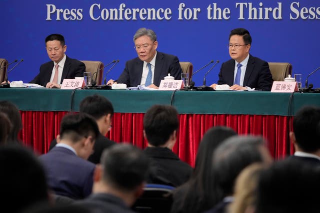 Wu Qing, chairman of the China Securities Regulatory Commission, Wang Wentao, commerce minister, and Zheng Shanjie, chairman of the National Development and Reform Commission at a press conference