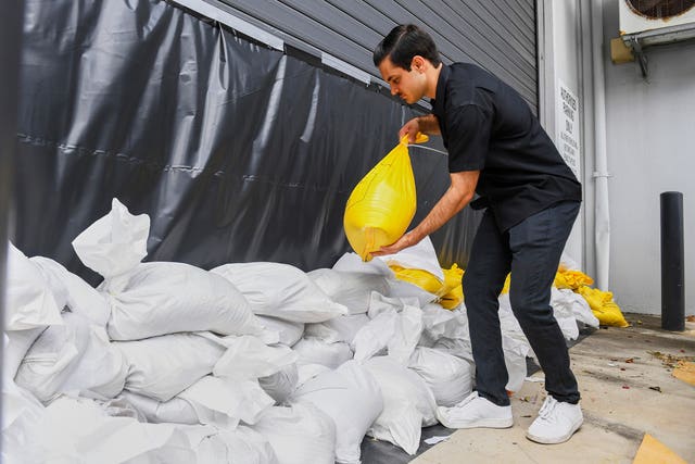 A worker installs sandbags at an engineering business in Brisbane 