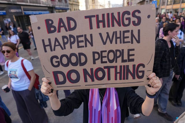 A banner is held up at a rally