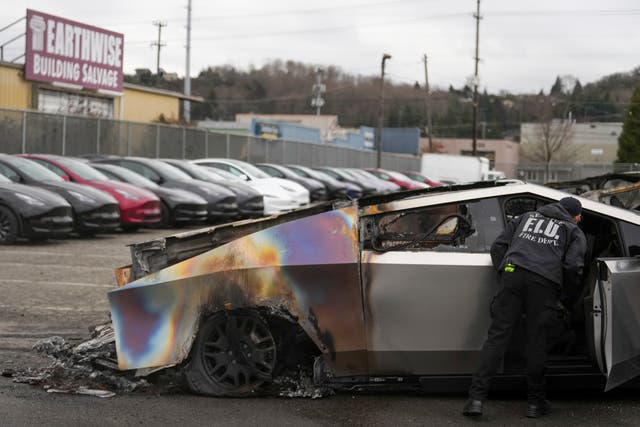 Firefighters inspect a burned Cybertruck at a showroom in Seattle