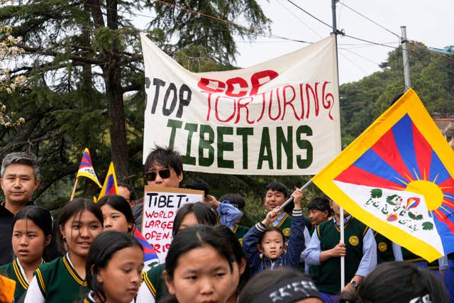 Tibetans bearing banners march in protest in New Delhi