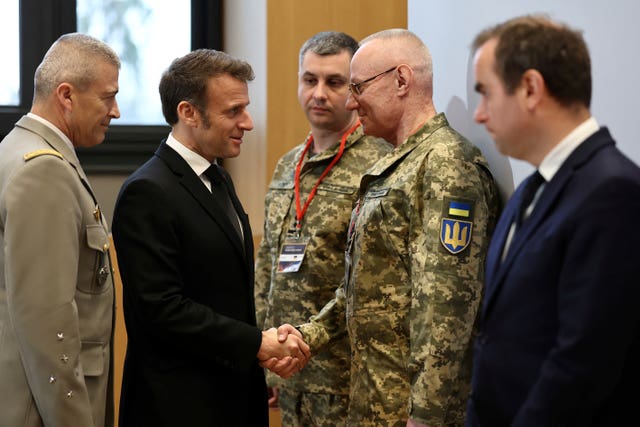 French President Emmanuel Macron shakes hands with Colonel-General Ruslan Khomchak, First Deputy Secretary of the National Security and Defence Council of Ukraine, as French Defence Minister Sebastien Lecornu, right, and Chief of Staff of the French Armed Forces Thierry Burkhard, left