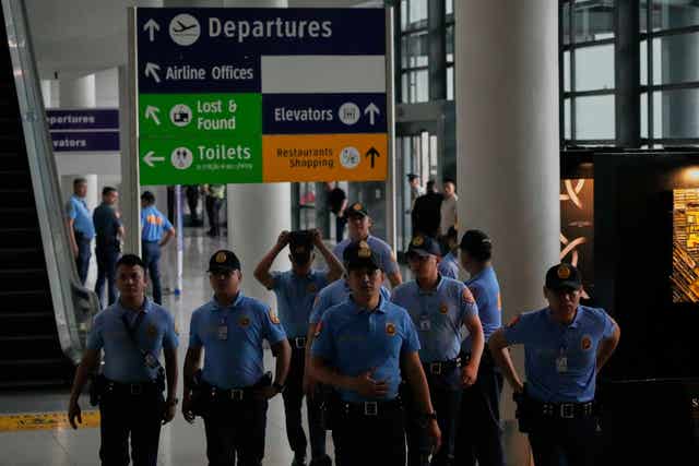 Security officers patrol the airport after former President Rodrigo Duterte was arrested in Manila