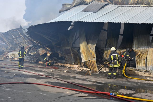 Firefighters put out the fire following a Russian drone attack that hit warehouses in Odesa