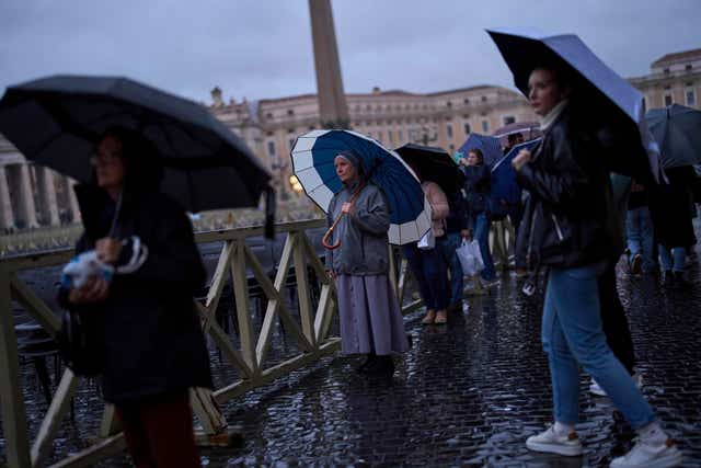 People listen to a live broadcast of a Rosary prayer for Pope Francis, in St Peter’s Square at the Vatican 