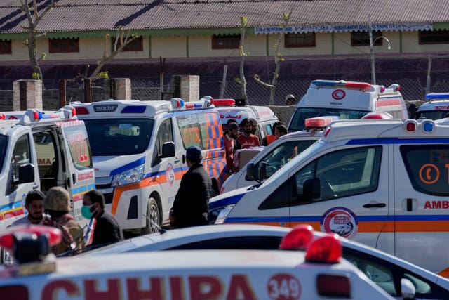 Ambulances wait for the arrival of the bodies of victims from the train attack