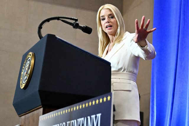 Pam Bondi stands at a lectern