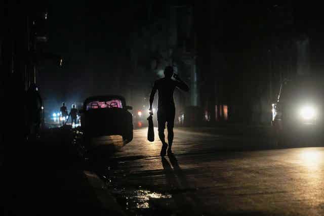 A resident walks on a street during the blackout in Havana