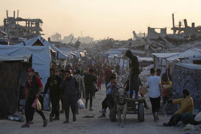 People walk among the rubble