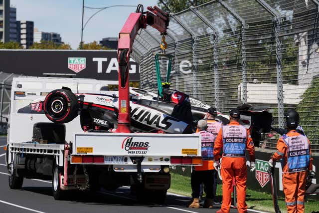 Track marshalls put Haas driver Oliver Bearman's car on a truck following a crash during the first practice session