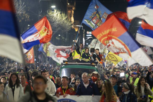 Flag-waving protesters on top of a vehicle