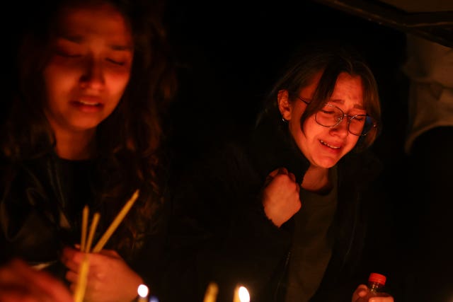 Girls cry as they light candles in the town of Kocani