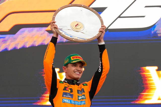 Lando Norris lifts up the victory shield after winning in Melbourne