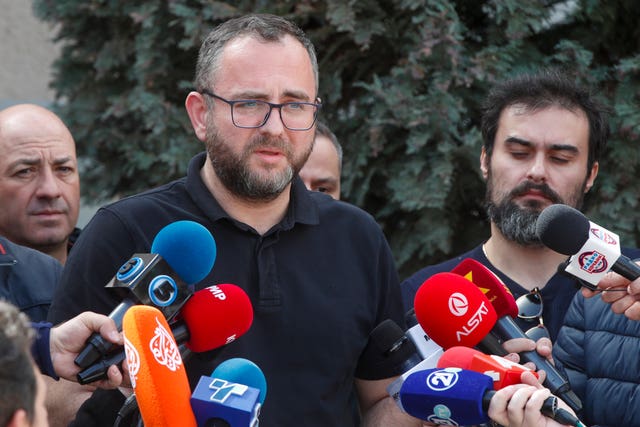 Pance Toskovski speaking, with numerous media microphones held towards him