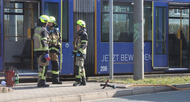 Firefighters stand outside a tram