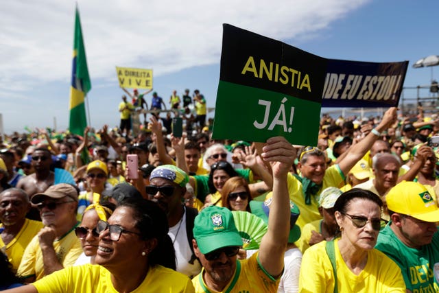 A supporter of former president Jair Bolsonaro holds up a sign that reads in Portuguese 'Amnesty Now'