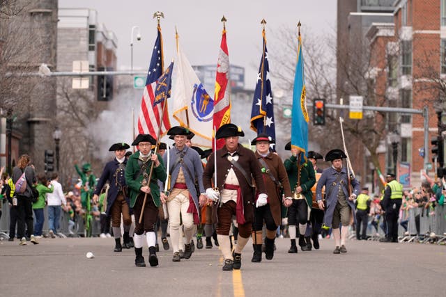 Participants dressed as Minutemen march marching in a St Patrick’s Day parade in Boston