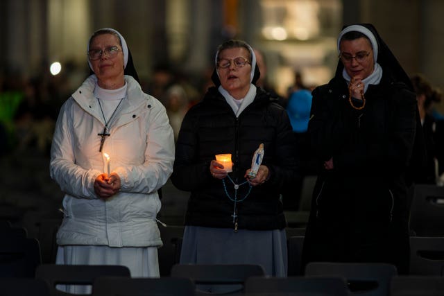 Nuns pray the rosary in St Peter’s Square at the Vatican on Sunday for the health of Pope Francis 