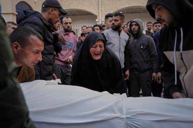 A woman weeps over the body of a person killed during airstrikes across the Gaza Strip