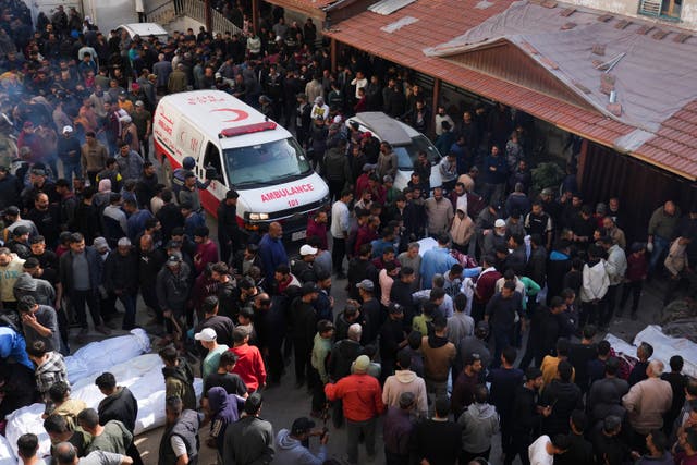 Mourners gather around the bodies of Palestinians who were killed in Israeli airstrikes 