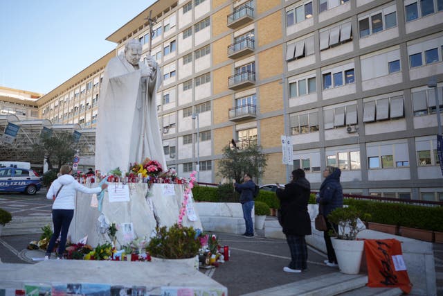 People pray for Pope Francis in front of the hospital