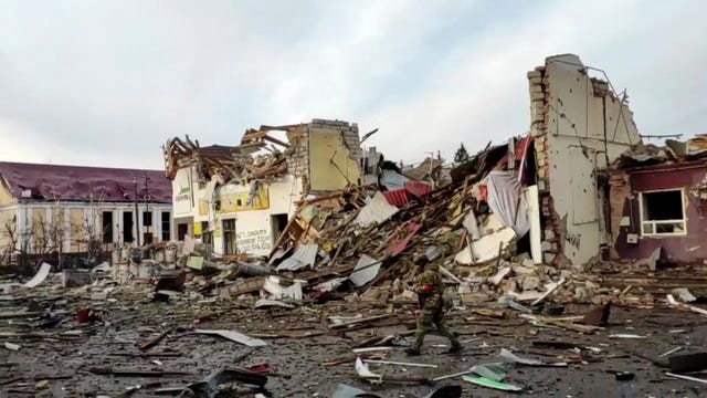 A Russian soldier patrols an area of destroyed buildings