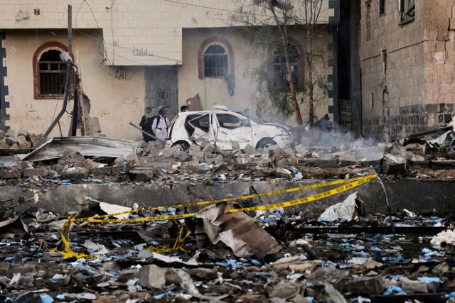 Locals inspect a site reportedly struck by US airstrikes overnight in Sanaa 