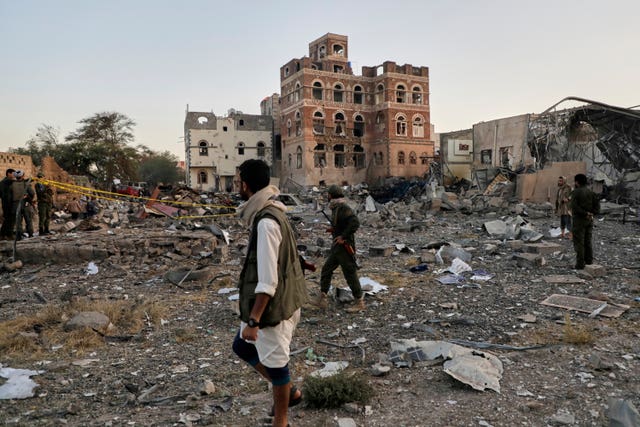 Locals inspect a site reportedly struck by US airstrikes overnight in Sanaa, Yemen 