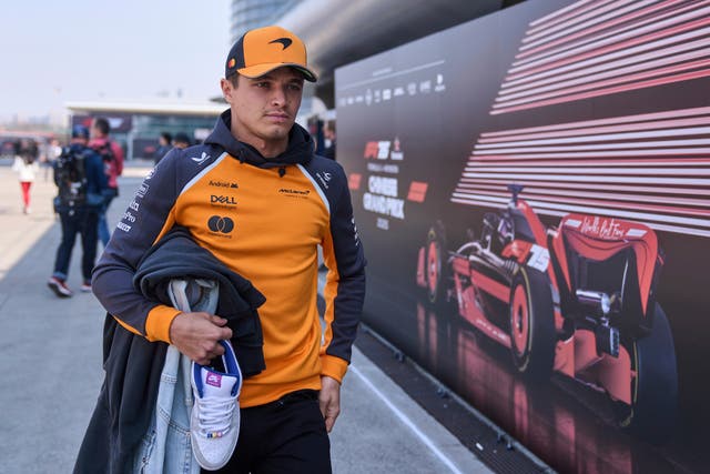 Lando Norris walks through the paddock in China