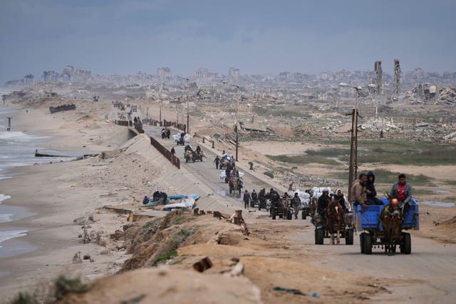 Stream of people carrying their belongings down a road