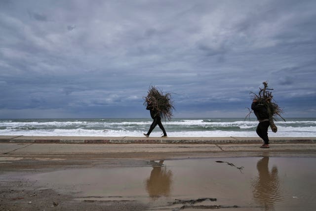 People carry bundles of wood