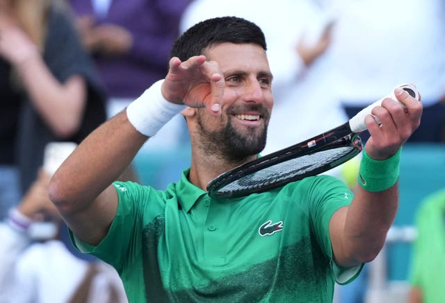 Novak Djokovic pretends to play his tennis racket like a violin