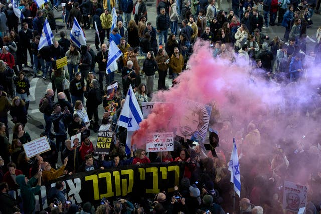 Crowd of demonstrators with smoke from a red/pink flare 