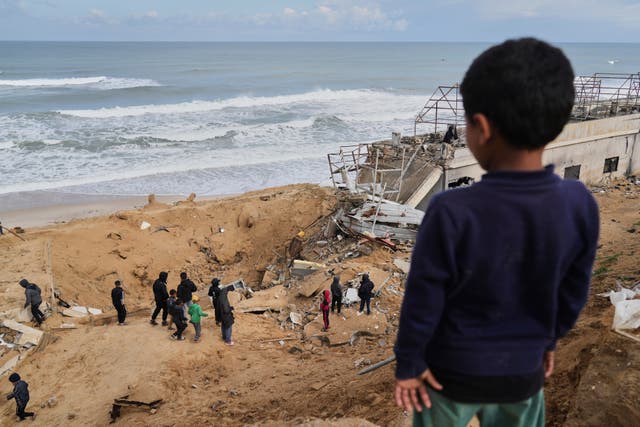 Palestinians inspect the rubble of a structure hit by an Israeli bombardment 