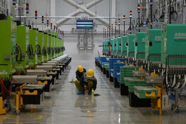 Workers scrub the floor at the factory in Binh Duong