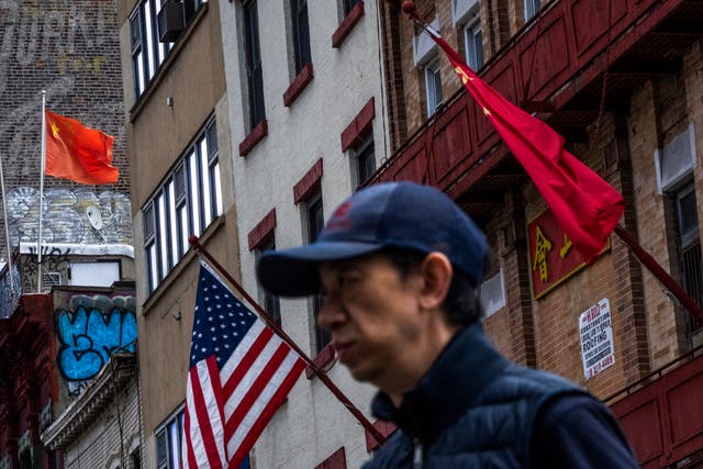Someone walks past US and Chinese flags in New York