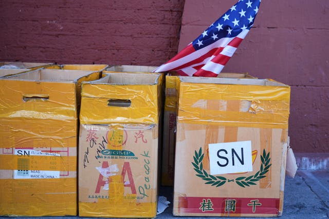 Cardboard boxes on a street with a small American flag in the Toy District of Los Angeles