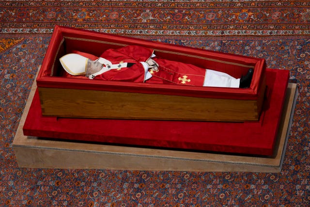 The body of Pope Francis inside a modest wooden coffin