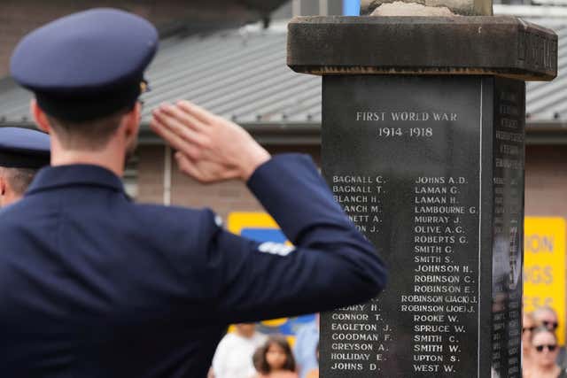 A honour guard officer salutes a memorial to the dead during Anzac Day commemorations in Nelson Bay, Australia