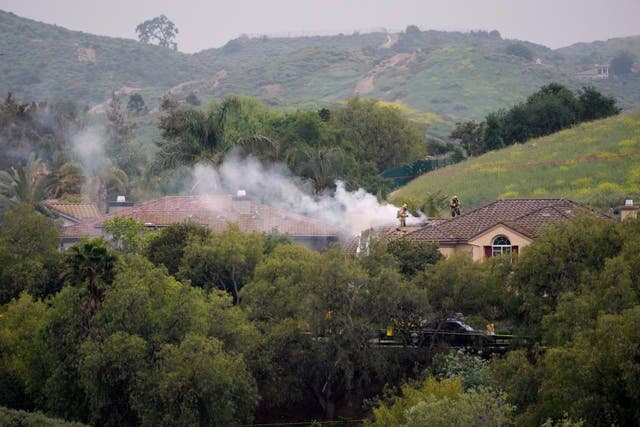 Firefighters work at the site of a plane crash