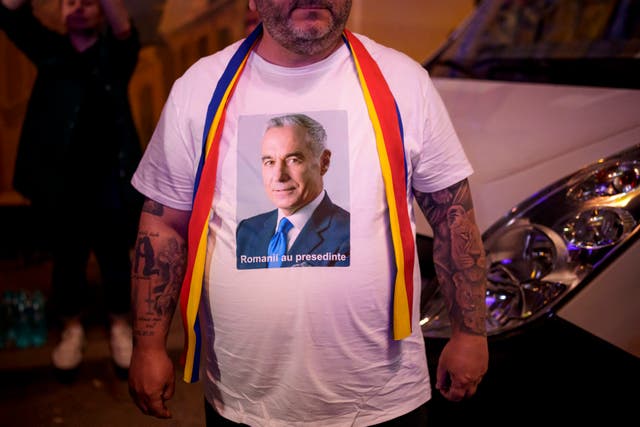A man wears a T-shirt with Calin Georgescu's image on it