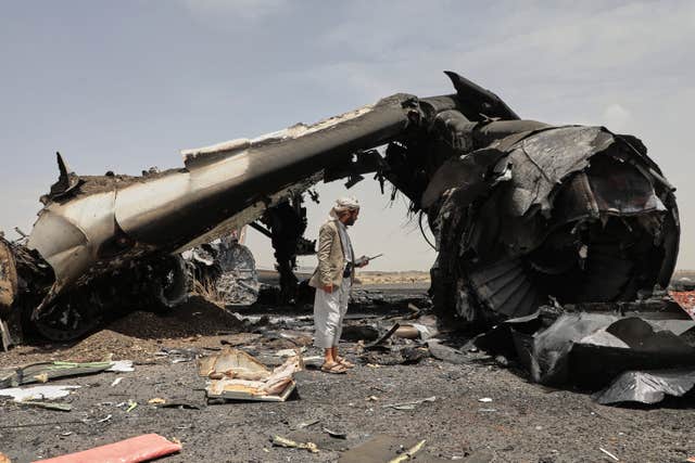 A Yemeni officer inspects the wreckage of a civilian aircraft after Israeli airstrikes on Sanaa International Airport 