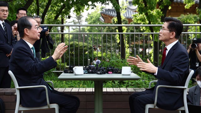 Kim Moon Soo, right, talks with his rival for the party candidacy Han Duck-soo before the decision to replace him