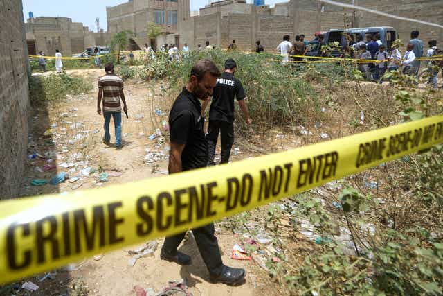 Pakistani investigators examine a cordoned off site, where Pakistan’s air defence system shot down a suspected Indian drone